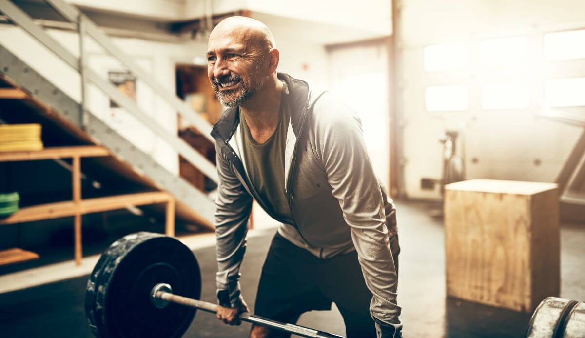 Mature man deadlifting during his workout