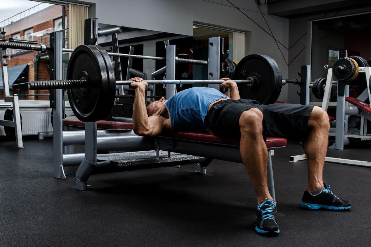 Man performing bench press during 6 day workout