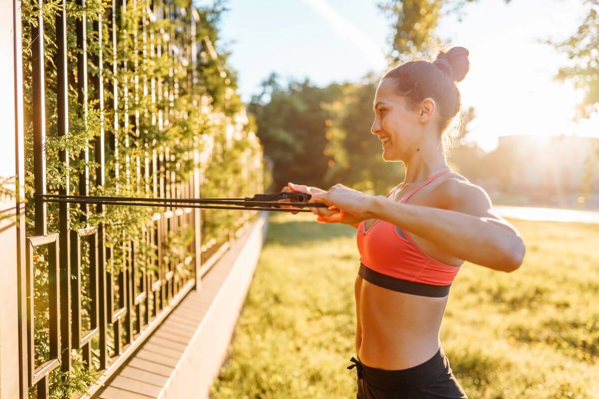 Woman performing resistance band rows outside