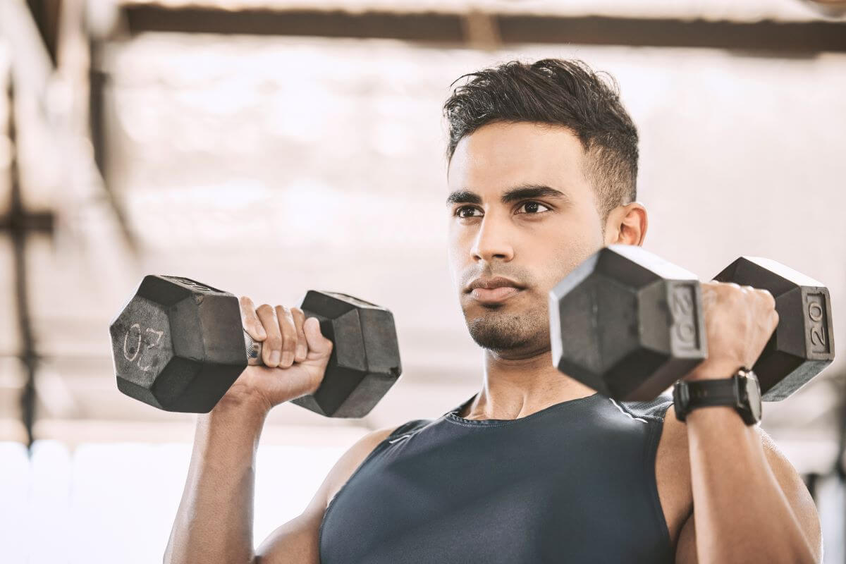 Man performing dumbbell exercises as part of 2 day dumbbell only workout