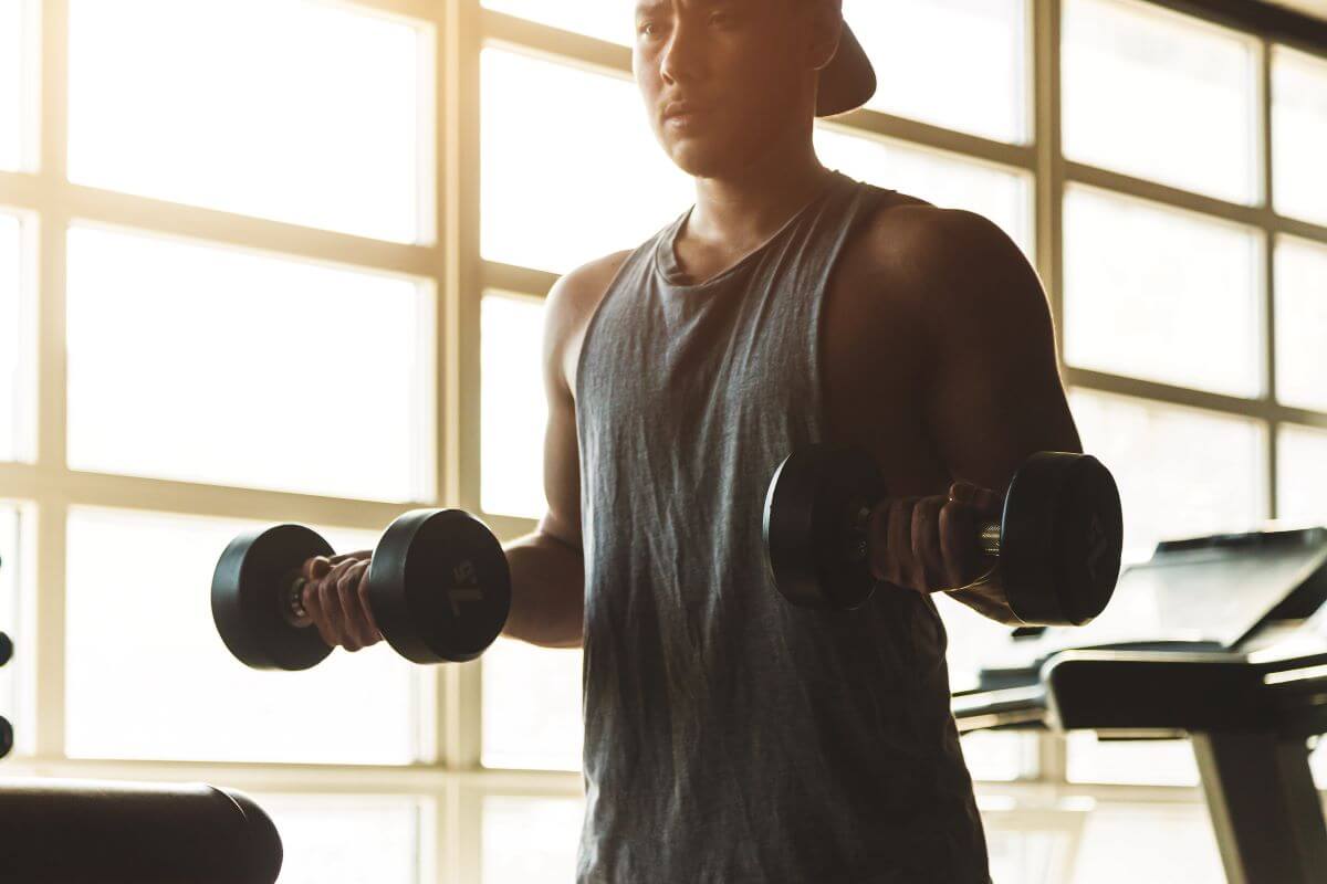 Man performing dumbbell exercise as part of 3 day push pull legs dumbbell workout