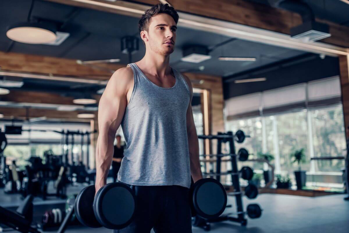 Man in the gym performing a 5 day dumbbell bro split