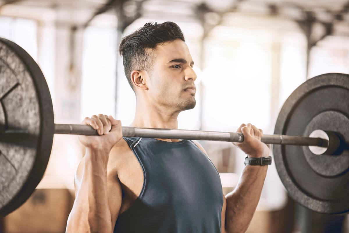 Man performing Shoulder Presses as part of AB Workout Split