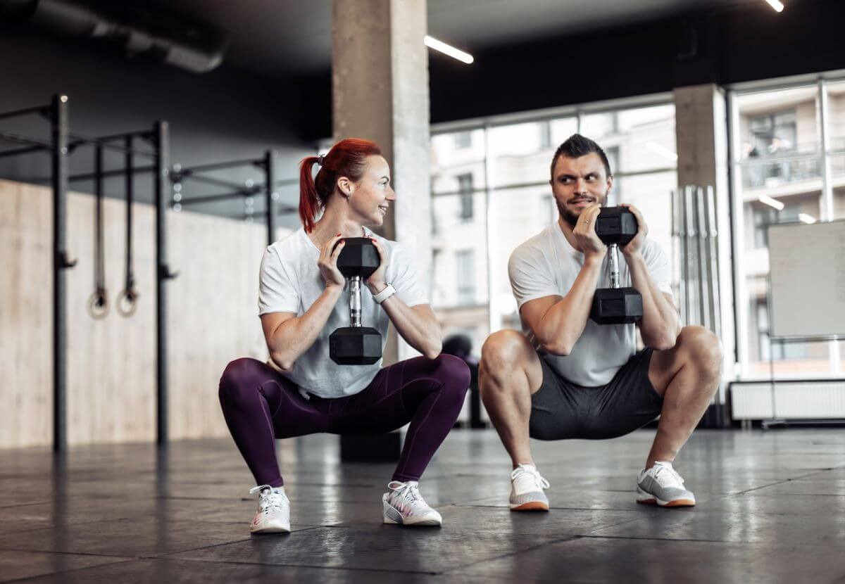 Man and woman performing dumbbell goblet squats as part of dumbbell only leg workout