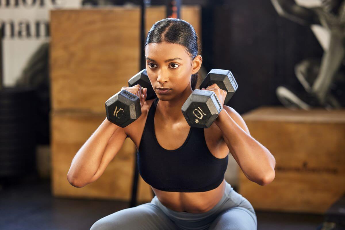 Woman performing a dumbbell squat exercise