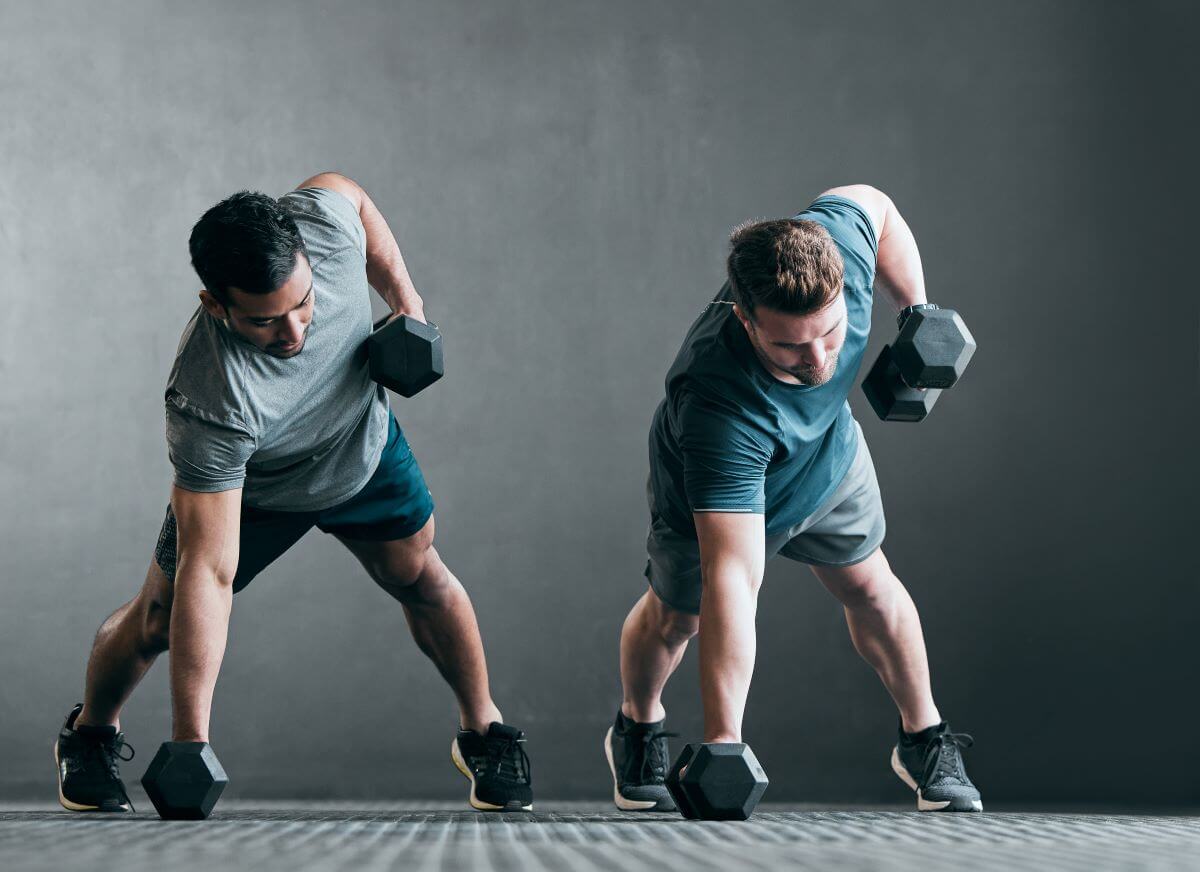 Men performing renegade rows as part of dumbbell back workout