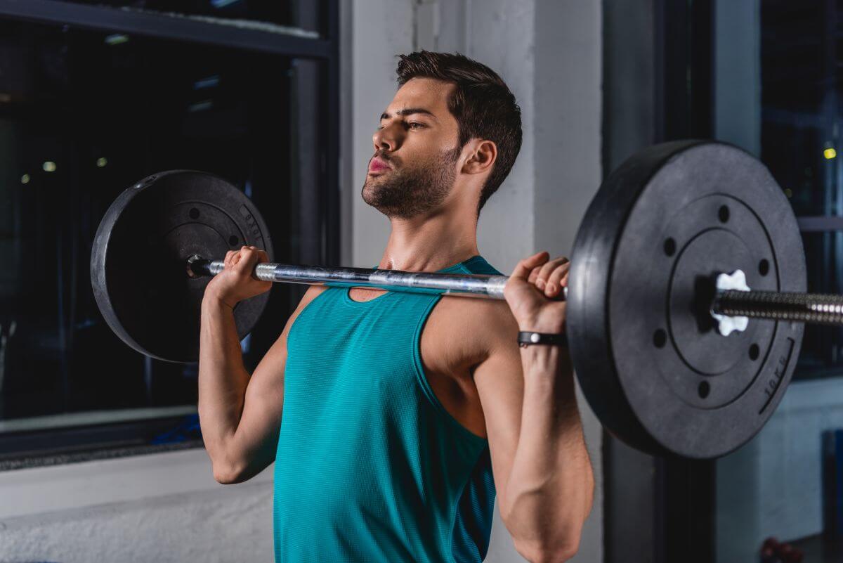 Man performing barbell shoulder press as part of a dumbbell and barbell workout plan