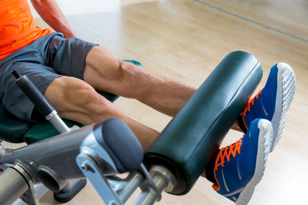 Man performing machine leg extension exercise at the gym